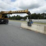 Gradall machine installing J-J Hooks precast concrete highway barrier for CSS, a division of Smith-Midland Corporation